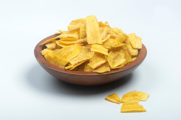 Studio shot of female hands picking Indian snack banana wafers from a scarved wooden bowl, isolated on white