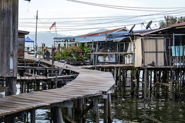 Fishing village houses over the water garbage poor areas in Sabah province in Malaysia