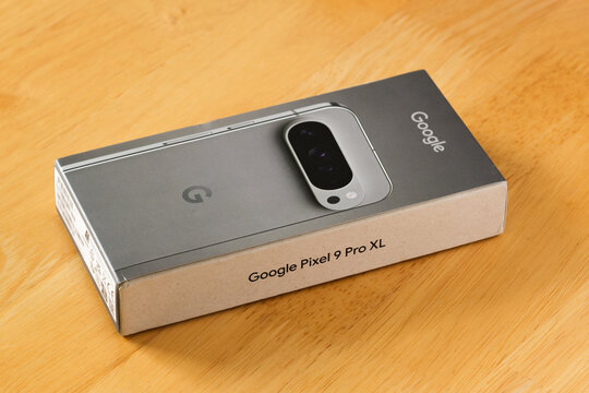 Google Pixel 9 Pro XL smartphone in matte Hazel Green, with retail packaging displayed on wooden and black backgrounds, Stafford, United Kingdom, August 22, 2024.