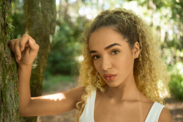 Portrait of fitness young woman in park near tree.