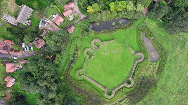 Aerial video footage of the remains of Bolingbroke Castle a 13th century hexagonal castle, birthplace of the future King Henry IV, with adjacent earthwork. and views of Old Bolinbroke Village.