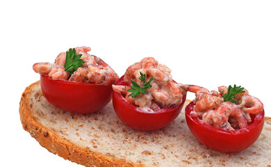 Three cocktail tomatoes with shrimps and parsley – a local delicacy called 'tomates crevettes' – on a slice of brown bread. On white