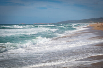 In Sardegna una spiaggia con la sabbia gialla e onde alte in estate.