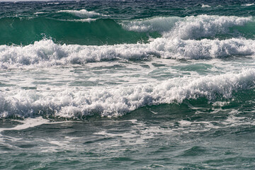 In Sardegna una spiaggia con la sabbia gialla e onde alte in estate.