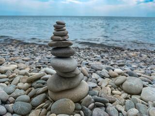 Stones stacked in pyramid standing on the seaside symbolizing tranqulity and buddhism concept