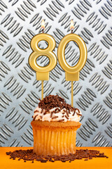 Chocolate cupcake with candle number 80 - Birthday on industrial metallic background.