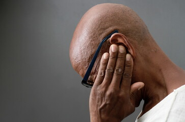 man suffering from deafness and hearing loss on gray background with people stock image stock photo	