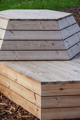 Close up of wood planks construction for sitting. Empty modern wooden bench. Brown ground. Tallinn, Estonia, Europe. July 2024