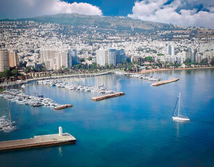 Naklejka premium Paisaje de embarcadero de veleros en el mar cerca a una ciudad.
