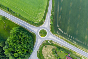 The roundabout road aerial view that newly developed. Summer sunny day. Roundabout on suburban road. Universal road photo. Road in agricultural fields landscape adn small town. © Michal
