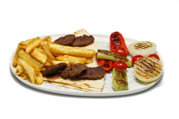 Plate of traditional grilled meatballs on white background