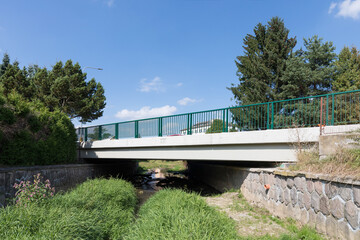 Reinforced concrete road bridge over the river. Close-up during sunny day in summer. Aerial view on...
