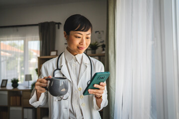 Japanese woman doctor have a coffee break and use mobile phone at work