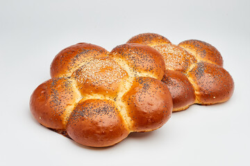 Freshly baked braided challah bread topped with sesame and poppy seeds, perfect for any meal