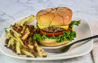 cheese burger  with fries top with bacon