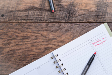 Calendar open to task page with schedule mammogram, handwritten in red ink.  Dark walnut tabletop.
