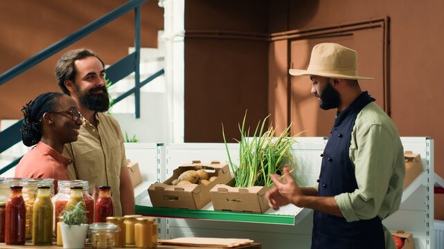 Shoppers at nearby zero waste green shop enquiring about organic cultivation and fresh vegetables kept in crates. Grocery store staff suggesting nutritious food selections to vegan couple.