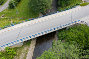 Reinforced concrete road bridge over the river. Close-up during sunny day in summer. Aerial view on...