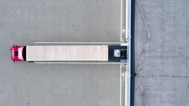 Truck with container is docked with loading area. Truck docking with logistic terminal