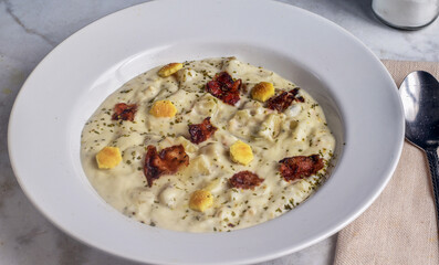 clam chowder top with bacon, parsley and crackers