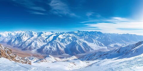 Fototapeta premium Wide angle view landscape of white snowy mountains range with clear blue sky during cold winter. Nature concept for extreme lifestyle product background