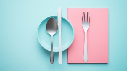 A vibrant table setting featuring a pastel blue plate, utensils, and a pink notebook, perfect for culinary inspiration. healthy diet and daily habits concept.