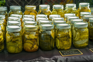 Homemade pint jars of pickled cucumbers at a local farmer's market