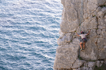 Frau in leichter toprope Route klettert an einer Fels Klippe bei Roc'hablok, Frankreich
