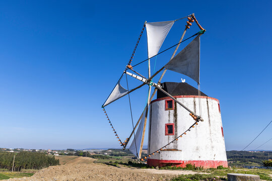 Portugal, Moita dos Ferreiros. Moinhos de Vento. Windmills Traditional Clay pots, jugs, used to catch the winds. Sails billowing.