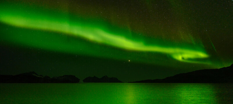 Northern Lights over Angmagssalik Fjord near settlement Kuummiit (formerly spelled Kummiut). Ammassalik area in East Greenland, Danish Territory.