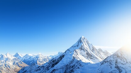 Fototapeta premium Majestic mountain range with snow-capped peaks and clear blue sky above. Majestic Mountain Range