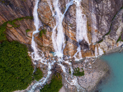 USA, Alaska, Tracy Arm-Fords Terror Wilderness, Waterfall flowing down cliff side along Endicott Arm near Dawes Glacier at dusk on summer evening