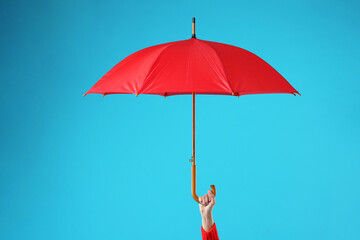 Woman with red umbrella on light blue background, closeup © New Africa
