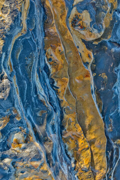 USA, California, Point Lobos State Natural Reserve. Blue and gold tone rocks at low tide.