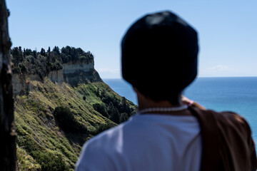 Man in the foreground looking out at a mountainside on the Island of Corfu in Greece.