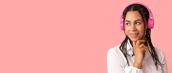 Beautiful African-American woman listening to music on pink background with space for text