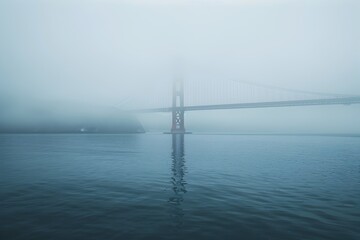 Obraz premium Mystical Suspension Bridge Shrouded in Ethereal Fog over Tranquil Waters