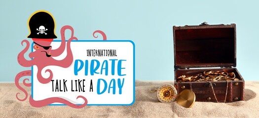 Old chest with treasure and compass on sand against light blue background. Banner for Talk Like a Pirate Day