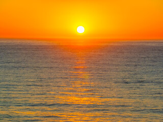 Sunrise seascape with clear skies and orange horizon