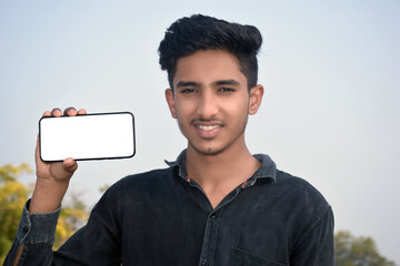 The schoolboy in a shirt with black demonstrates a smart phone screen. Focus on the smart phone. Conceptual. Copy space