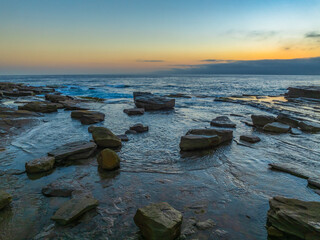 Obraz premium Sunrise seascape and rocky Inlet with thick fog cloud over the ocean