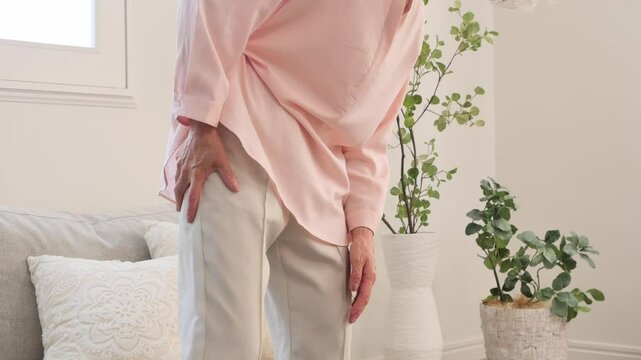 坐骨神経痛のシニア女性　リビングルーム