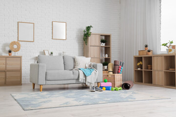 Sneakers, sportswear and different sports equipment in living room