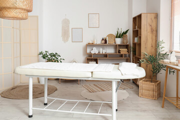 Interior of spa salon with couch, tables and shelf units