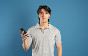 Portrait of asian man posing on blue background