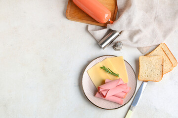 Plate with slices of tasty boiled sausage, cheese and bread on grunge white background