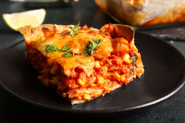 Plate with piece of tasty enchilada on table, closeup