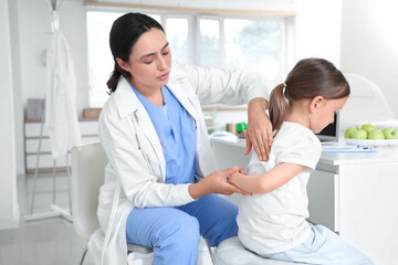 Obraz premium Female osteopath working with little patient in clinic