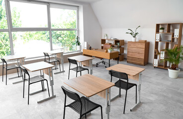 Interior of stylish empty classroom with chairs and desk