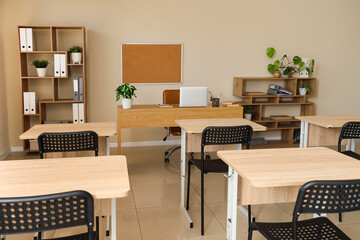 Interior of modern classroom with desks and chairs at school